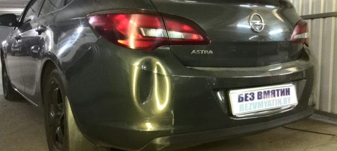 Opel Astra — вмятина на заднем бампере.