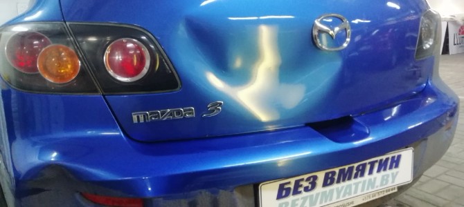 Mazda 3 — вмятина на крышке багажника.