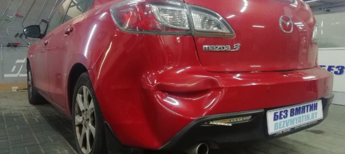 Mazda 3 — вмятина на заднем бампере.